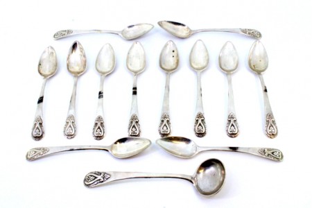 Conjunto de doze colheres de chá e concha de açúcar em prata com relevos nos cabos.